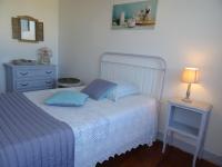 a bedroom with a bed and a lamp on a table at Le Clos Fleuri in Caumont