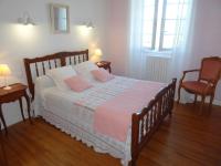 a bedroom with a bed with two tables and two chairs at Le Clos Fleuri in Caumont