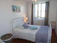 a bedroom with a bed with two pillows and a window at Le Clos Fleuri in Caumont