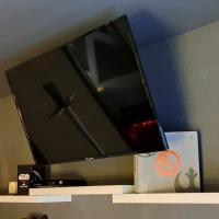 a flat screen tv sitting on top of a shelf at Hôtel Les Deux Porches in Verrières