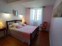 a bedroom with a bed with a pink blanket at Le Clos Fleuri in Caumont