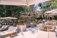 an outdoor patio with tables and chairs and umbrellas at Gili Divers Hotel in Gili Trawangan