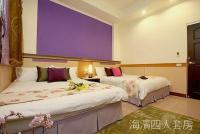 two beds in a hotel room with a purple wall at Hualien Hai Bin Homestay in Hualien City