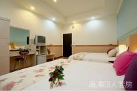 a hotel room with two beds and a desk at Hualien Hai Bin Homestay in Hualien City