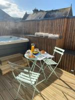 a table and chairs on a deck with a hot tub at La Maison du Quai Triplex de charme 4 étoiles en hyper centre avec SPA in Landerneau