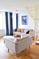 a living room with two couches and a staircase at La Maison du Quai Triplex de charme 4 étoiles en hyper centre avec SPA in Landerneau