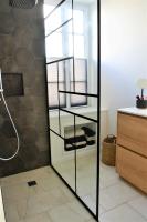a glass shower door in a bathroom with a sink at La Maison du Quai Triplex de charme 4 étoiles en hyper centre avec SPA in Landerneau
