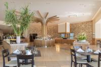 un ristorante con tavoli, sedie e piante di Horizon Beach Resort a Mastichárion