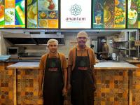 two men wearing aprons standing in a kitchen at Hotel ESSENCE in Vellore