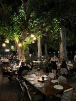 een groep mensen die aan tafels in een restaurant zitten bij Panellinion Luxury Rooms in Kalamata