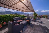 eine Terrasse mit Stühlen und Tischen unter einem Baldachin in der Unterkunft Hotel Gran Plaza Euromaya in Antigua Guatemala