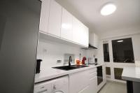 a white kitchen with white cabinets and a sink at Bel appartement meublé 4 pièces in Ris-Orangis