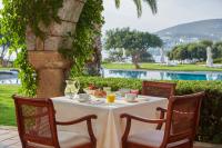 uma mesa branca com cadeiras e uma mesa com comida em Elounda Beach Hotel & Villas, a Member of the Leading Hotels of the World em Elounda