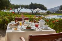 uma mesa com comida para o pequeno almoço com vista para o oceano em Elounda Beach Hotel & Villas, a Member of the Leading Hotels of the World em Elounda