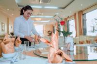 een vrouw aan een tafel in een restaurant bij Hung Long Harbour Hotel in Cat Ba