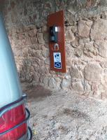 a parking meter on a stone wall with a red car at Chambres d&#39;hôtes La Hulotte 69 in Villechenève