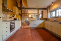 a kitchen with white cabinets and a red tile floor at Vakantiewoning De Luysmolen in Bocholt