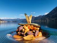 a pile of food on a plate on a table near water at Villa Belvedere Como Lake Relais in Argegno
