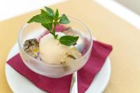 a bowl of ice cream on a plate with a spoon at Testa di Monaco Natural Beach in Capo dʼOrlando