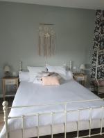 a bedroom with a white bed with two tables at LES 5 ESCALES in Parthenay