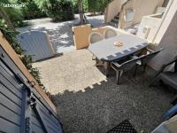 a patio with a table and chairs in a backyard at Sur la Presqu&#39;île des Dosses in Le Barcarès