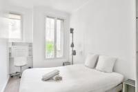 a white bedroom with a white bed and a window at Superbe T2 à proximité du parc Georges Brassens in Paris