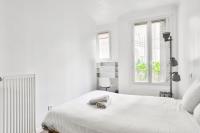 a white bedroom with a bed and a window at Superbe T2 à proximité du parc Georges Brassens in Paris