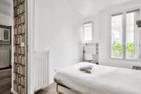 a white bedroom with a bed and a book shelf at Superbe T2 à proximité du parc Georges Brassens in Paris