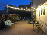 a patio with chairs and a table and lights at Pause au pied des Cevennes in Alès