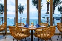 a table in a restaurant with a view of the ocean at Flamingo Cát Bà Resort Managed by Flamingo Hotels & Resorts in Cat Ba