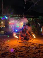 马拉帕斯加Tribal Huts Community的一个男人坐在火堆前的地上。