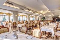 een eetkamer met tafels en stoelen en ramen bij Villa Romita in SantʼAgata sui Due Golfi