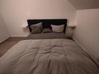 ein großes Bett in einem Schlafzimmer mit zwei Kissen in der Unterkunft Les Lofts De Provins: Apt 8 in Provins