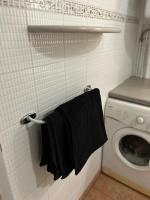 a black towel hanging on a wall next to a washing machine at TAN&#39;MAYEVA APPART * in Mamoudzou