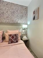 a bedroom with a bed with a pink bedspread at &#39;&#39;Les Platanes&#39;&#39;de Miss.K Conciergerie in Gorrevod