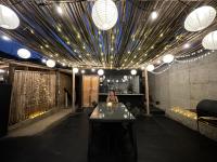 una persona sentada en una mesa en una habitación con luces en Lobitos Eco Lodge, en Lobitos