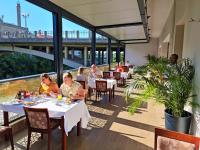 grupa ludzi siedząca przy stołach w restauracji w obiekcie Hotel Bristol w mieście Mostar