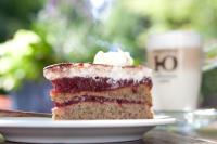 a piece of cake on a plate with a cup of coffee at Behringers Freizeit - und Tagungshotel in Gößweinstein