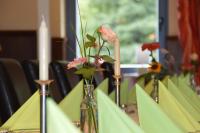 a table with a vase with flowers in it at Behringers Freizeit - und Tagungshotel in Gößweinstein