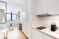 a kitchen with white cabinets and a bed in a room at Les Appartements de Grenoble in Grenoble