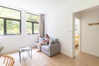 a woman sitting in a chair in a living room at Les Appartements de Grenoble in Grenoble