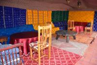 扎古拉Riad le Petit Jardin的房间里有椅子、桌子和色彩斑斓的墙壁。