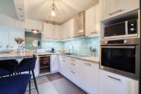 a kitchen with white cabinets and a black microwave at Magnifique Appart Stade de France gare Terasse Paris 6 pers in Saint-Denis