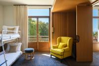 a room with a bed and a chair and a window at Hôtel Royal in Évian-les-Bains