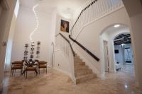 ein Esszimmer mit einer Treppe, einem Tisch und Stühlen in der Unterkunft Miami Getaway Heated Pool Villa with Mini Golf &amp; BBQ in Miami