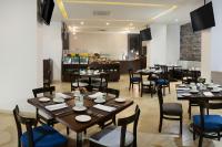 un restaurant avec des tables et des chaises en bois et un comptoir dans l'établissement Gran Hotel de Puebla by HNF, à Puebla