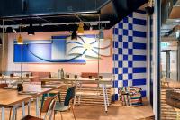 Un restaurante con mesas y sillas y un reloj en la pared. en Villa Viva - ein Haus das Brunnen baut, en Hamburgo