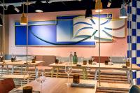 Un restaurante con mesas y un gran cartel en la pared. en Villa Viva - ein Haus das Brunnen baut, en Hamburgo