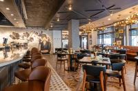 Un restaurante con mesas y sillas y un mural. en Hotel Flor Tampa Downtown, Tapestry Collection By Hilton, en Tampa