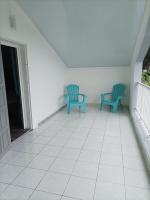 two blue chairs sitting on a porch with a balcony at Villa Imelda à saint André la réunion in Le Patelin